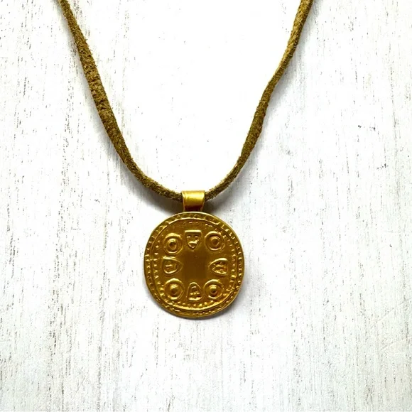 Mayan design gold tone pendant purchased in Costa Rica, on golden suede cord
